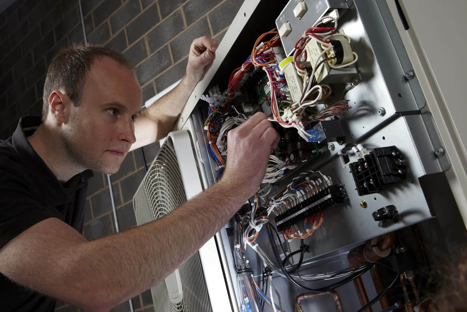 A man Check electric wire of air source Heat Pump